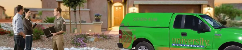 Pest control technician talking with a couple outside a house, with a green company truck parked nearby.