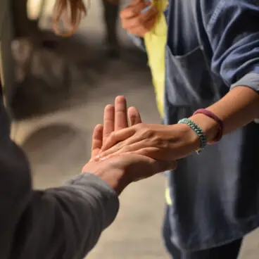 Two people clasping hands in a gesture of support or connection