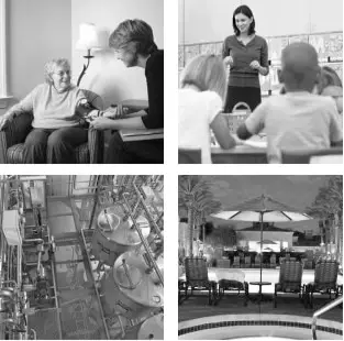 An image showing a classroom setting with two people seated at desks, and a woman standing in the background.